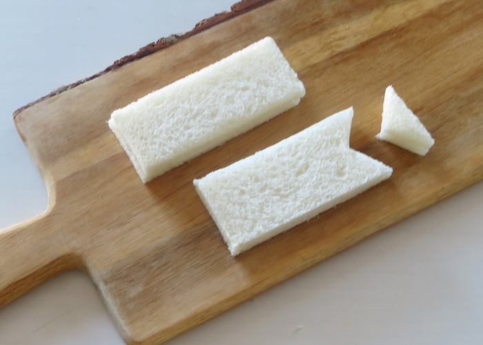 「鯉のぼりサンド」のつくり方　食パンを半分に切り、一方の端を三角に切り落とす